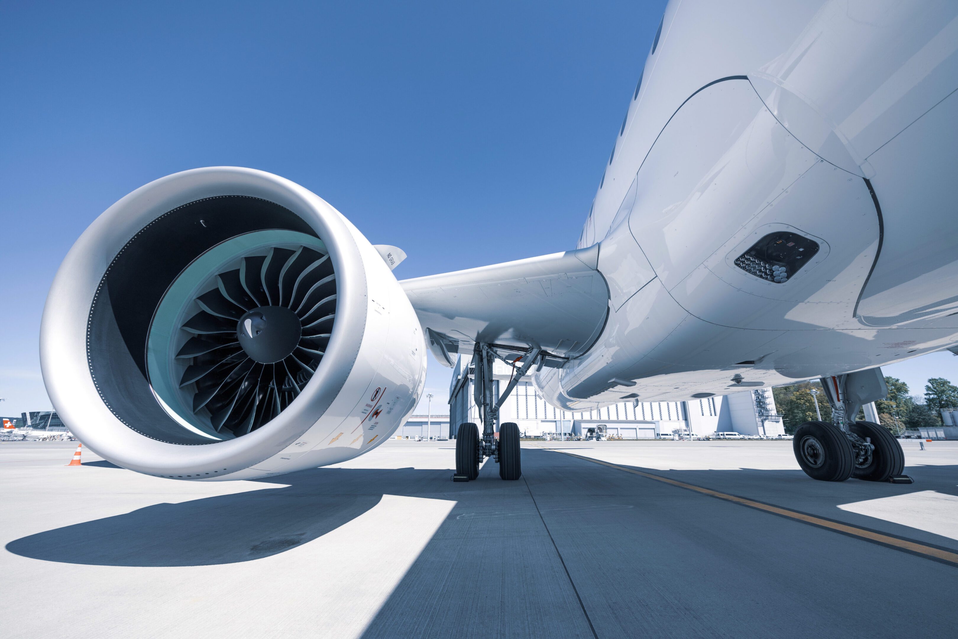Airplane engine and landing gear on tarmac.