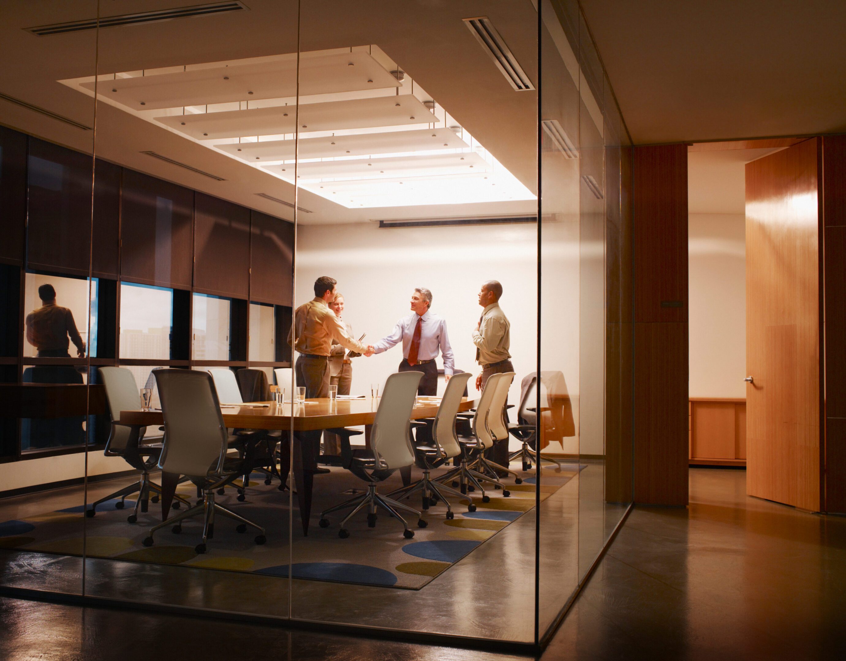 People shaking hands in a conference room.