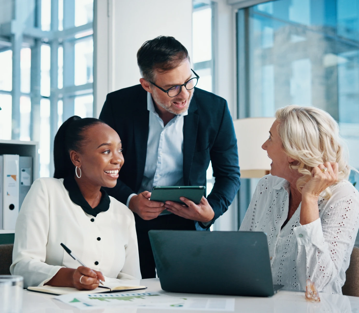 Three colleagues discussing work in office.